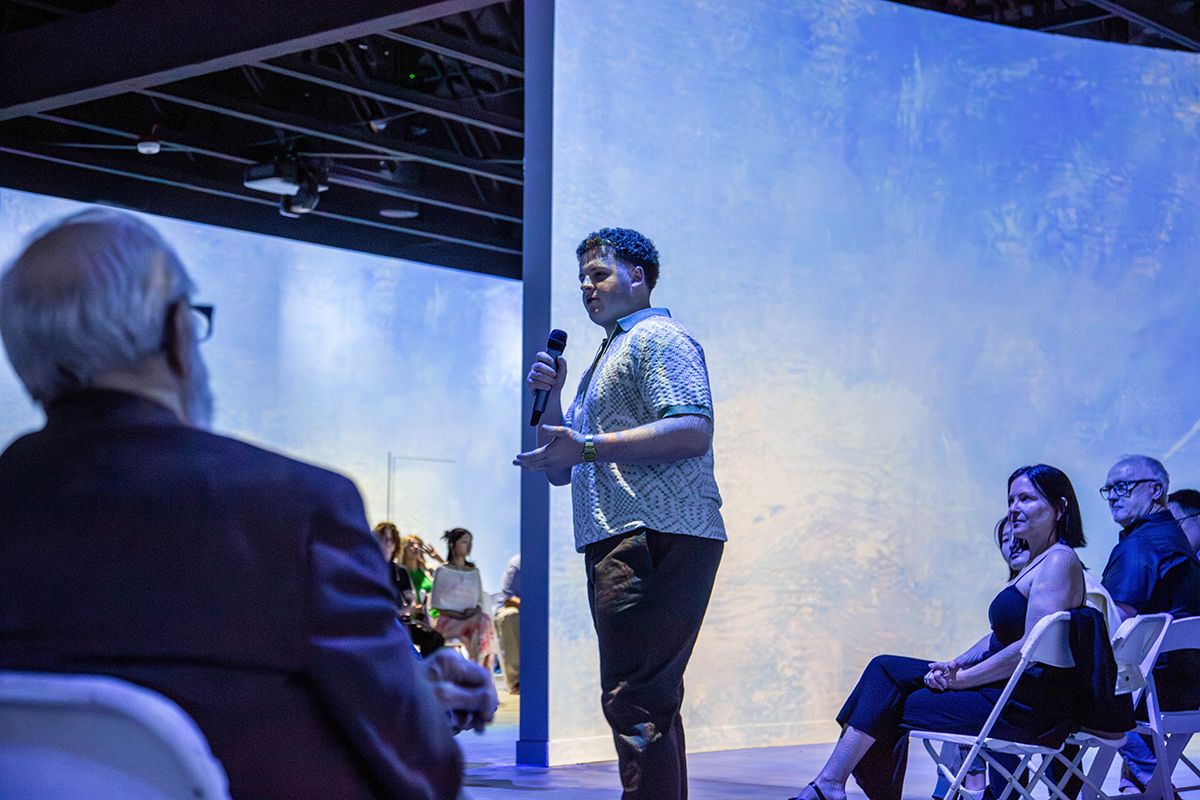 Declan Taylor, senior in fashion studies and marketing, addresses the audience during the K-State's Fashion Studies Showcase of Excellence, sharing the inspiration and creative process behind his collection. Photo by Kristina Bonner/K-State News and Communications Services. 