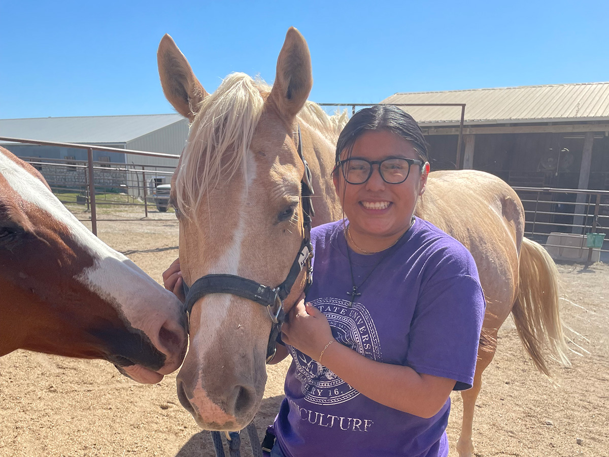 Sara Lopez holds a horse during a campus event at K-State.