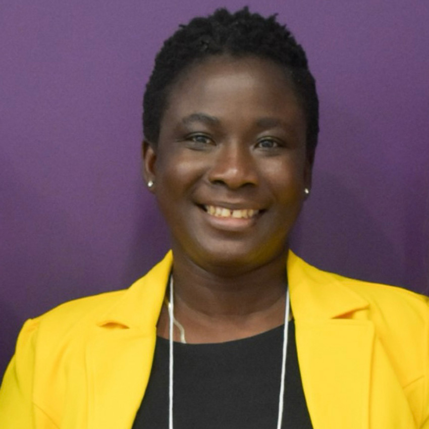 Ernestina Wiafe smiles for a professional portrait against a purple backdrop