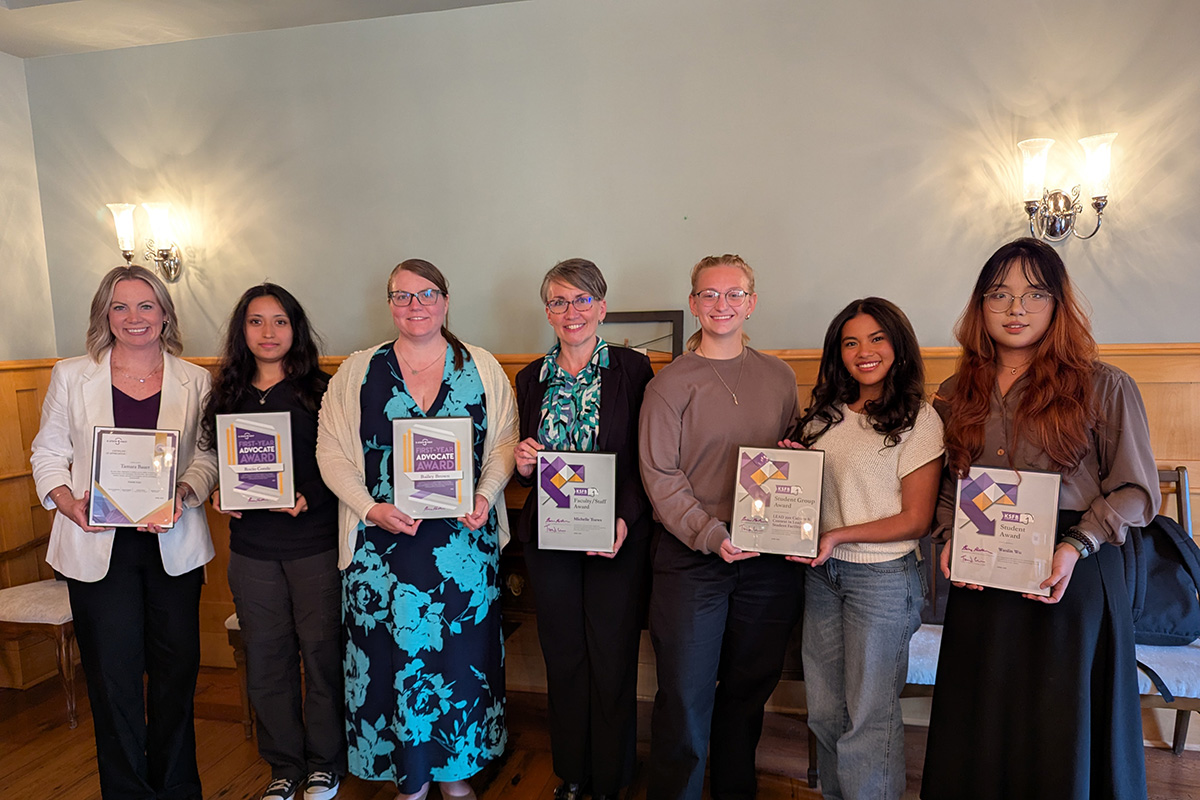 Tamara Bauer, Rocio Conde, Bailey Brown, Michelle Toews, Abby Meyer, Suzette Navarro and Wanlin Wu stand together for a group photo while holding their award plaques.