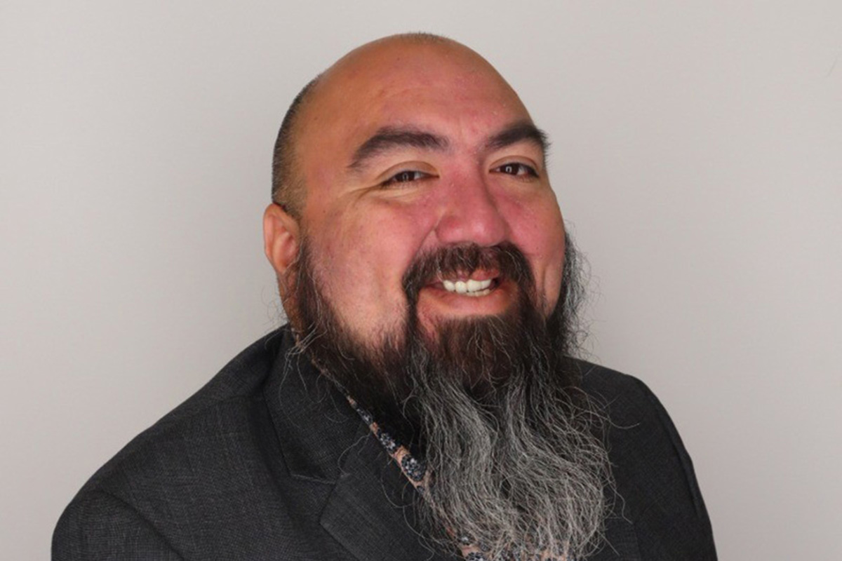 Anthony Ybarra smiles for a professional portrait. 