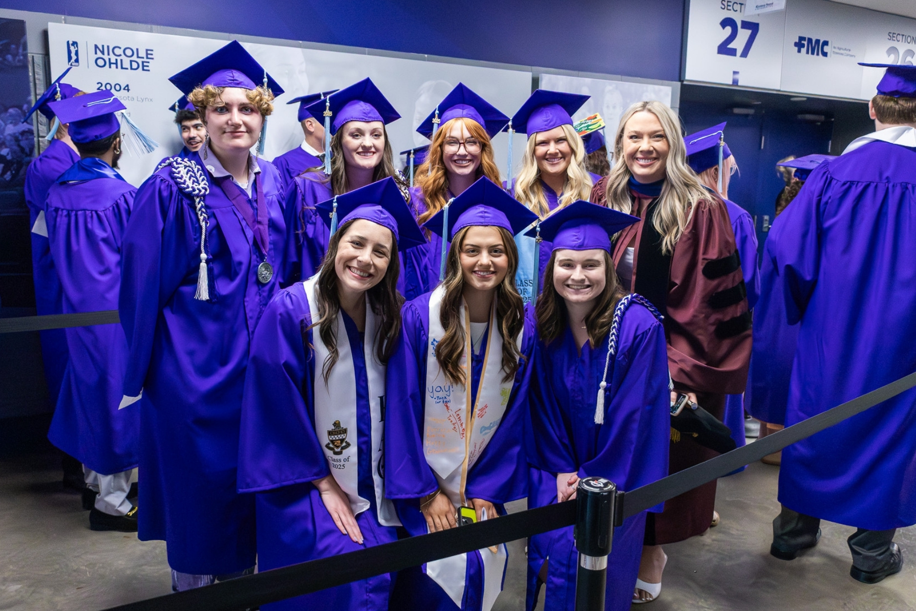 Rios and students pose together for a photo at graduation