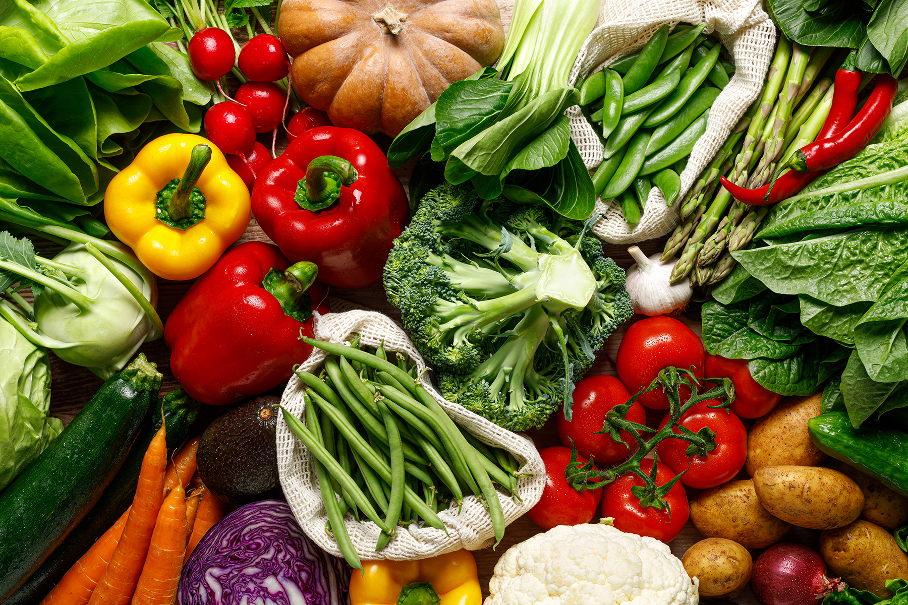 An overhead view shows various vegetables on a table.
