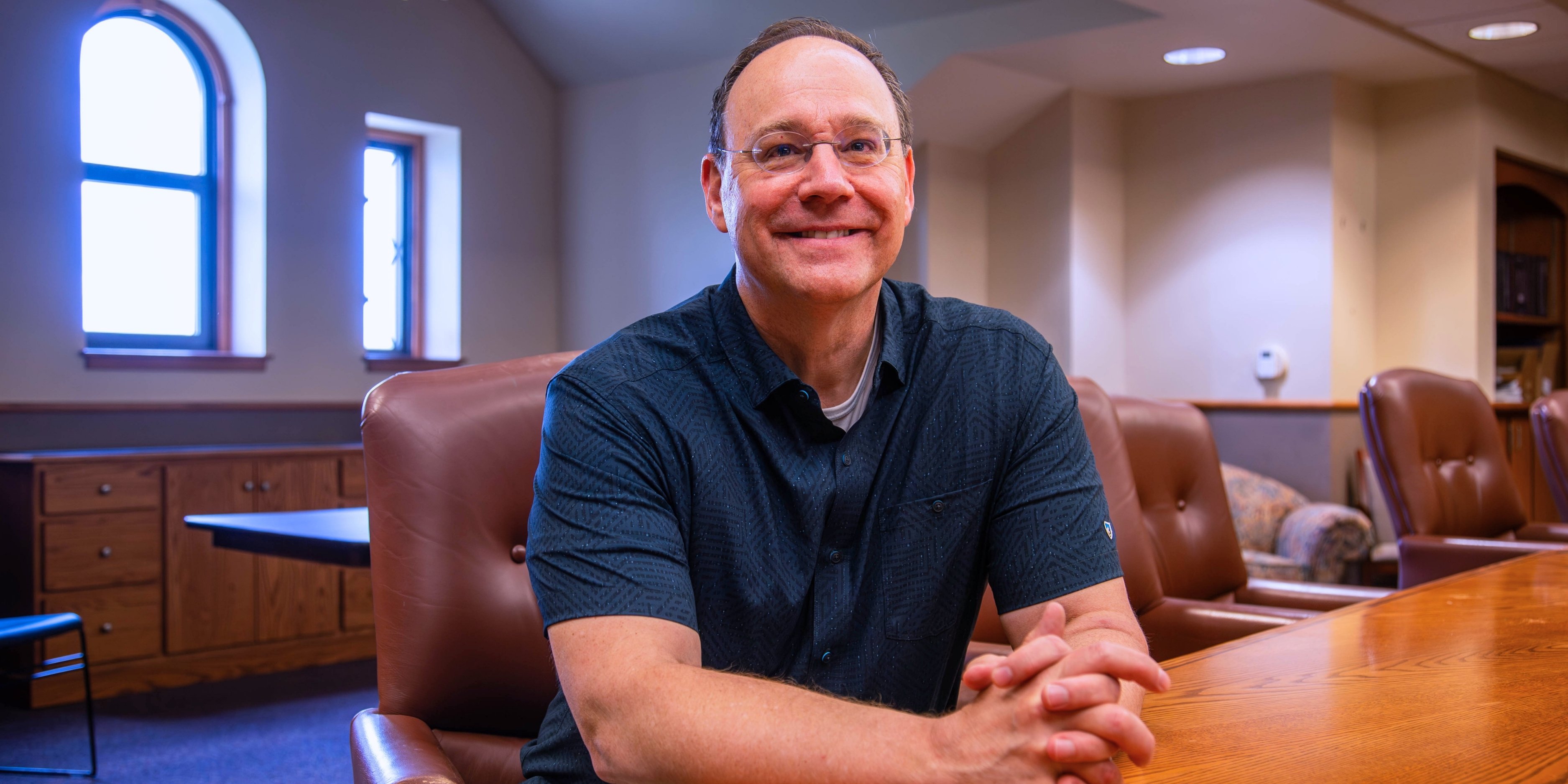 Jeff Pickering poses for a portrait photo in a conference room