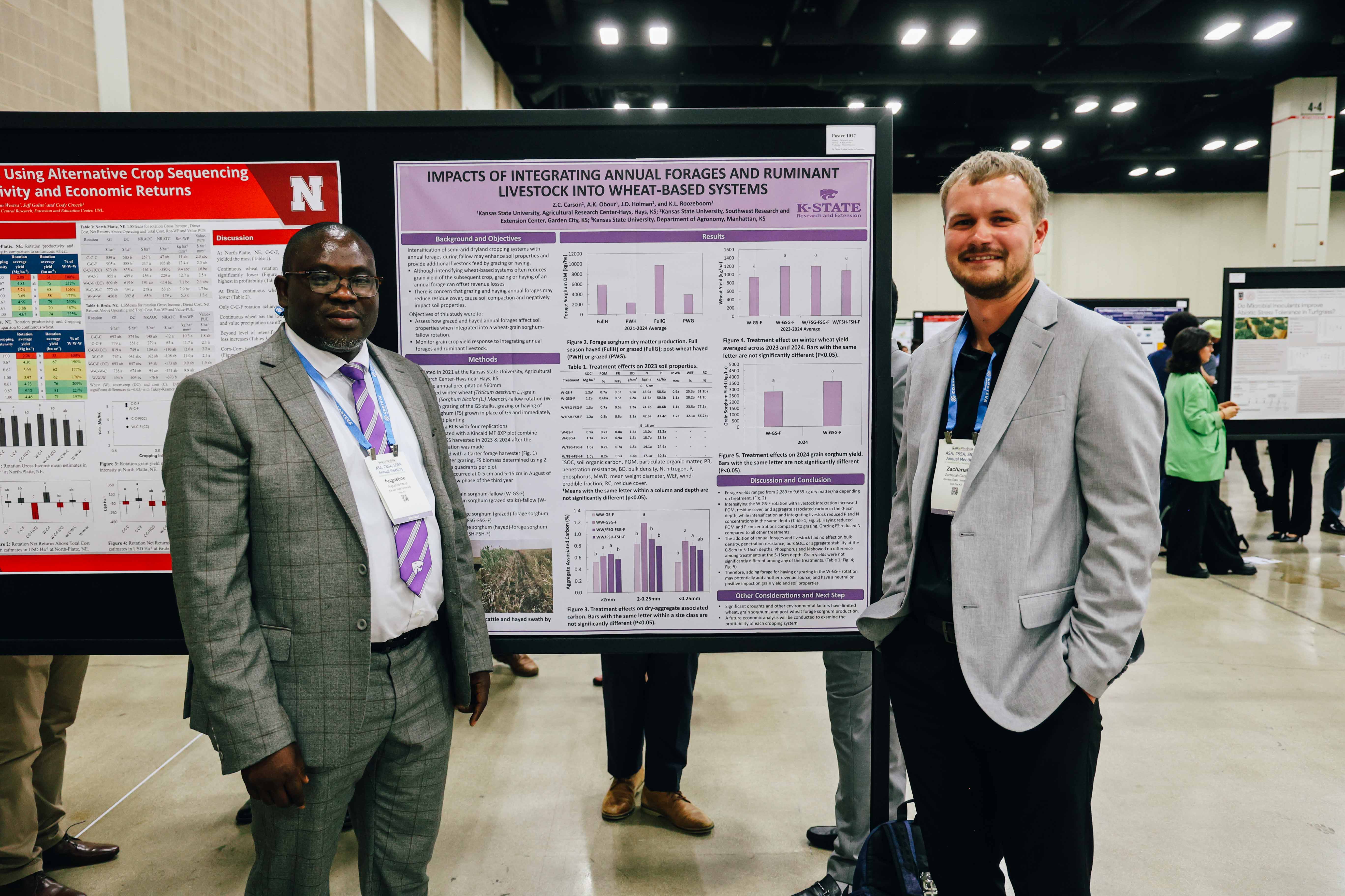 A Black professor and a white grad student stand on either side of a research poster.