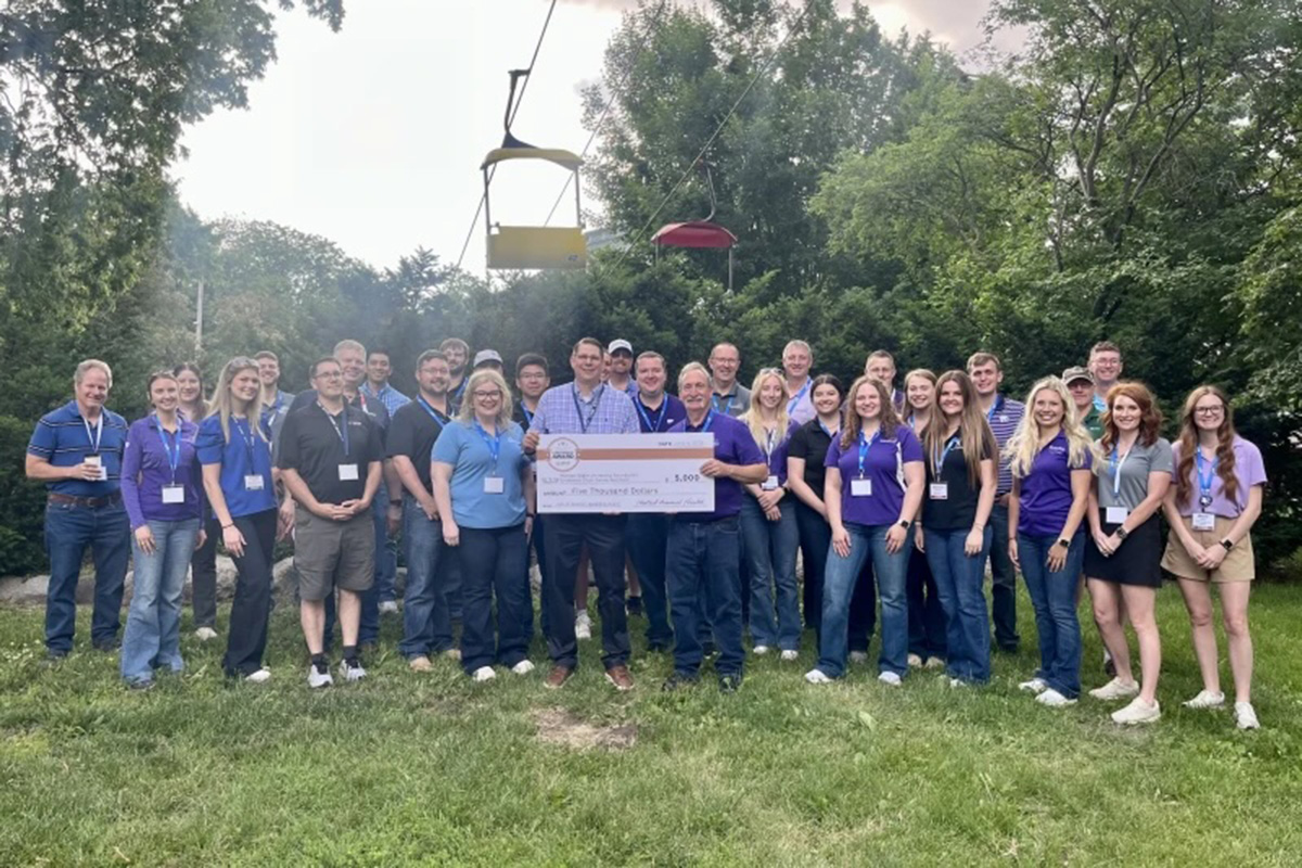 A group of professionals at the World Pork Expo pose with Robert Goodband and the award check after winning the John B. Swisher Leadership Award