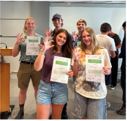 College students pose with paper certificates. 