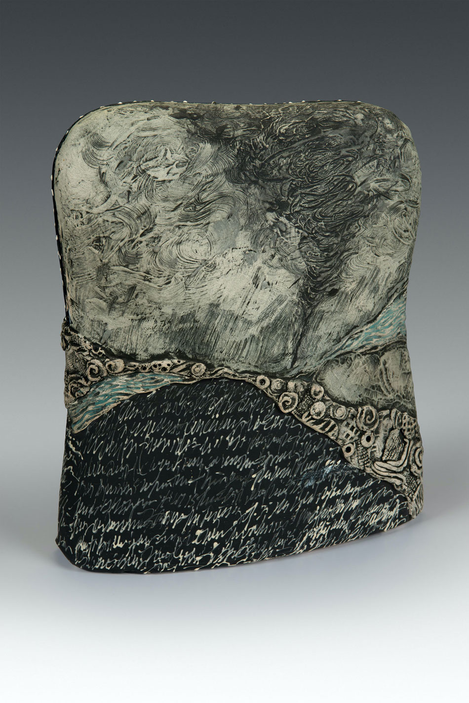 A piece of art that looks like a rounded rectangular stone tablet abstractly depicting a tornado.