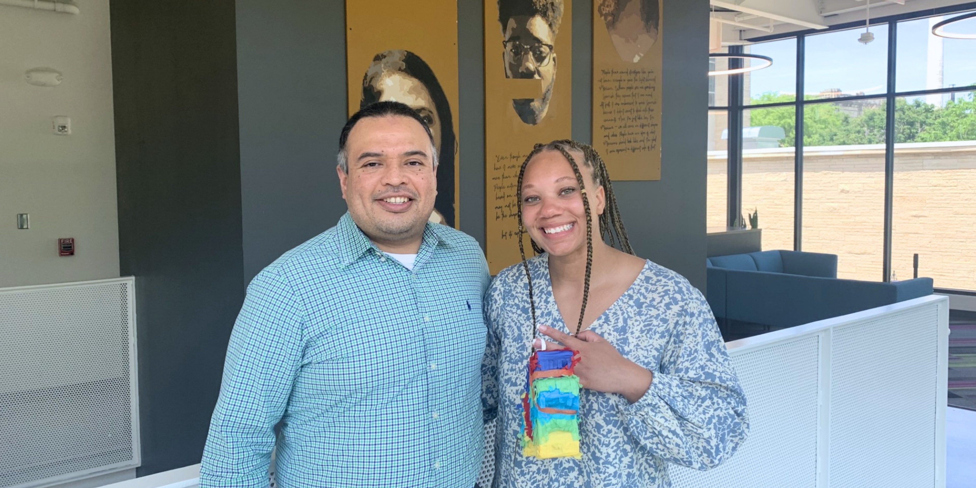 Kevin Santos Flores stands smiling with a student.