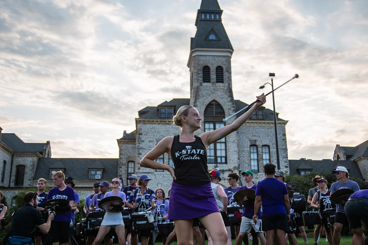 Kaylee Brungardt twirls alongside the Pride of Wildcat Land marching band during the K-State Kickoff. Kristina Bonner/Division of Communications and Marketing.
