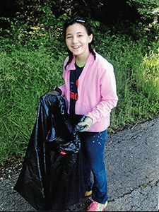 Lauren Seybold as a child holding a trash bag to pick up litter. 