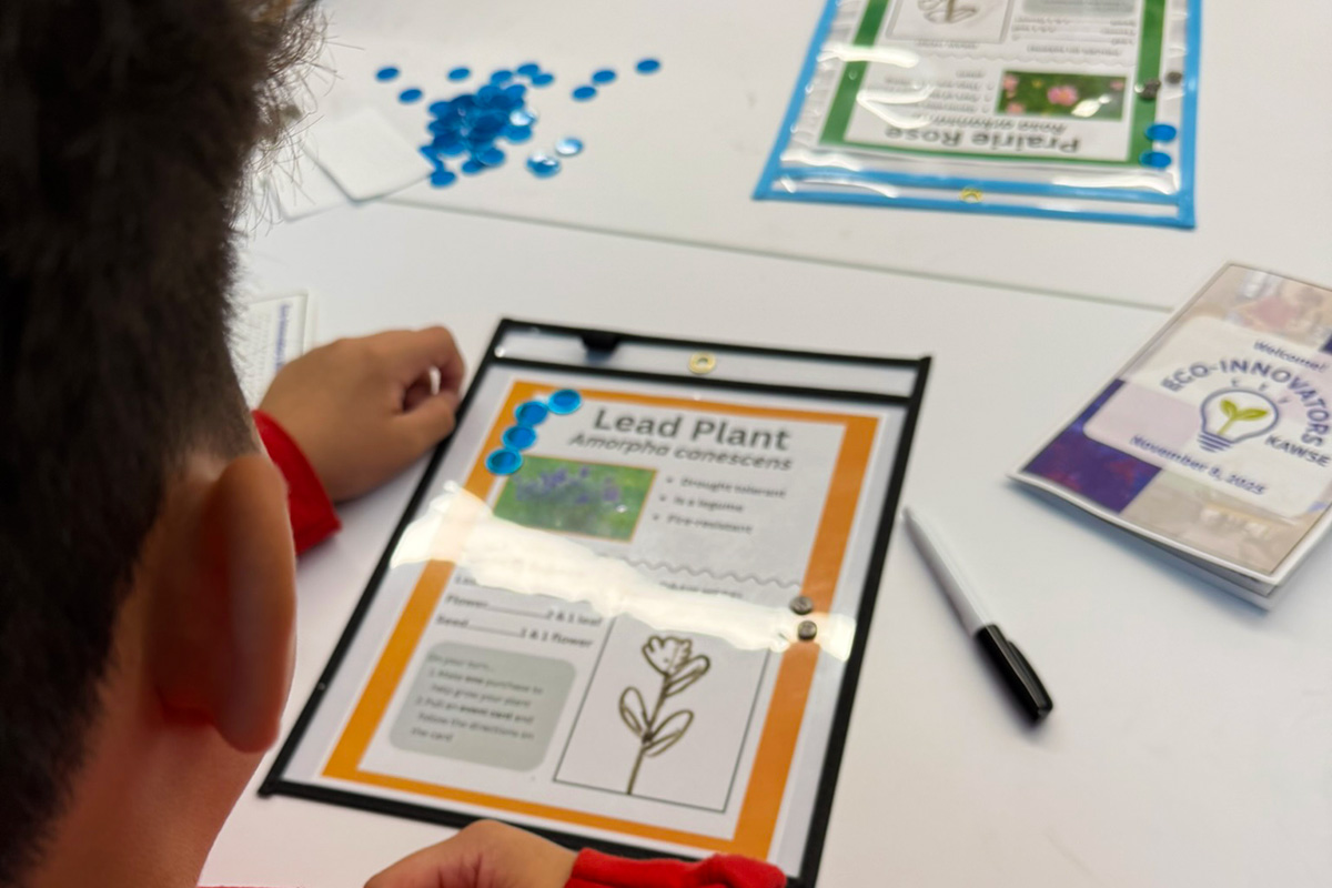 A close up photo of middle school students playing a scientific board game.