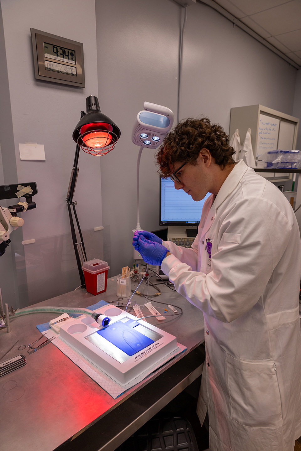 A graduate student works with a pipette at a research lab bench.