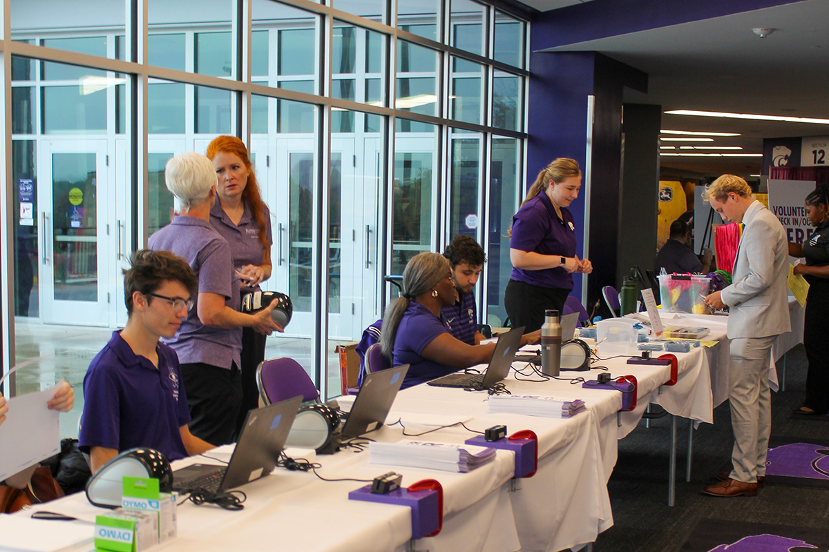 A group of college students works at a university career fair.