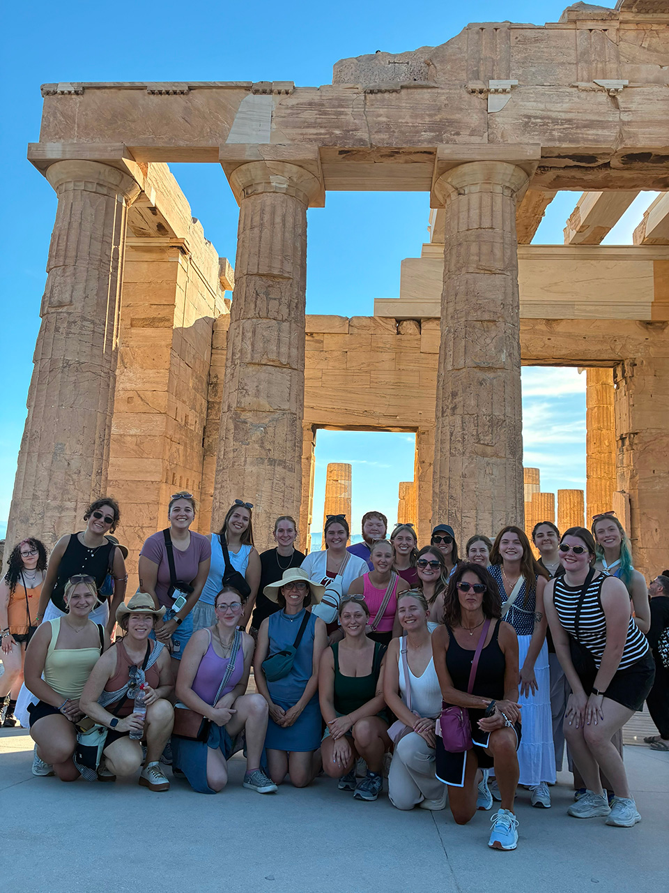 Gerentolgy and Psychology programs group together for a photo outside the Parthenon Temple in Athens, Greece prior to arriving on the island of Ikaria.