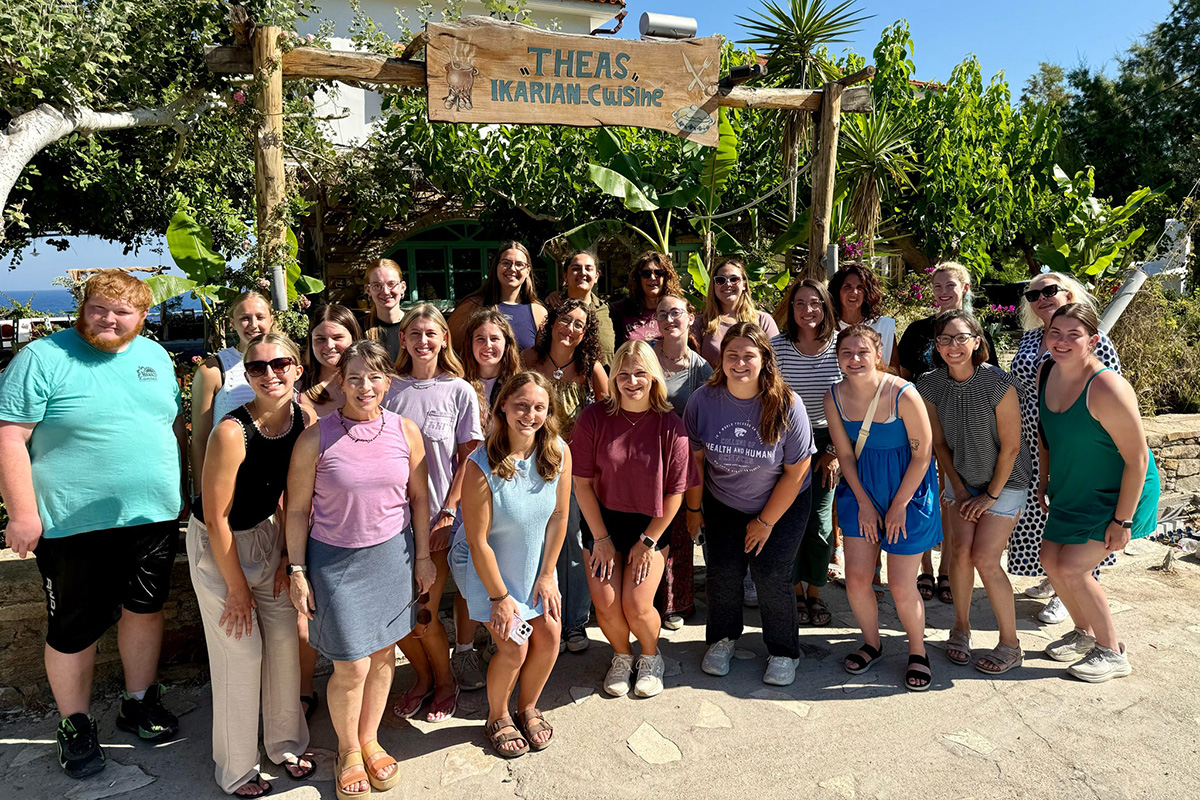 Gerentolgy and Psychology programs group together for a photo outside their tour guide and host’s restaurant, Thea’s Ikarian Cuisine.