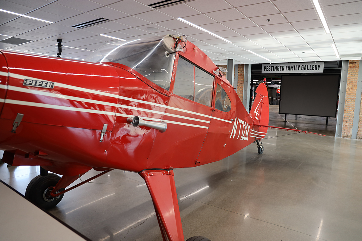 A close-up of a red plane in a museum.