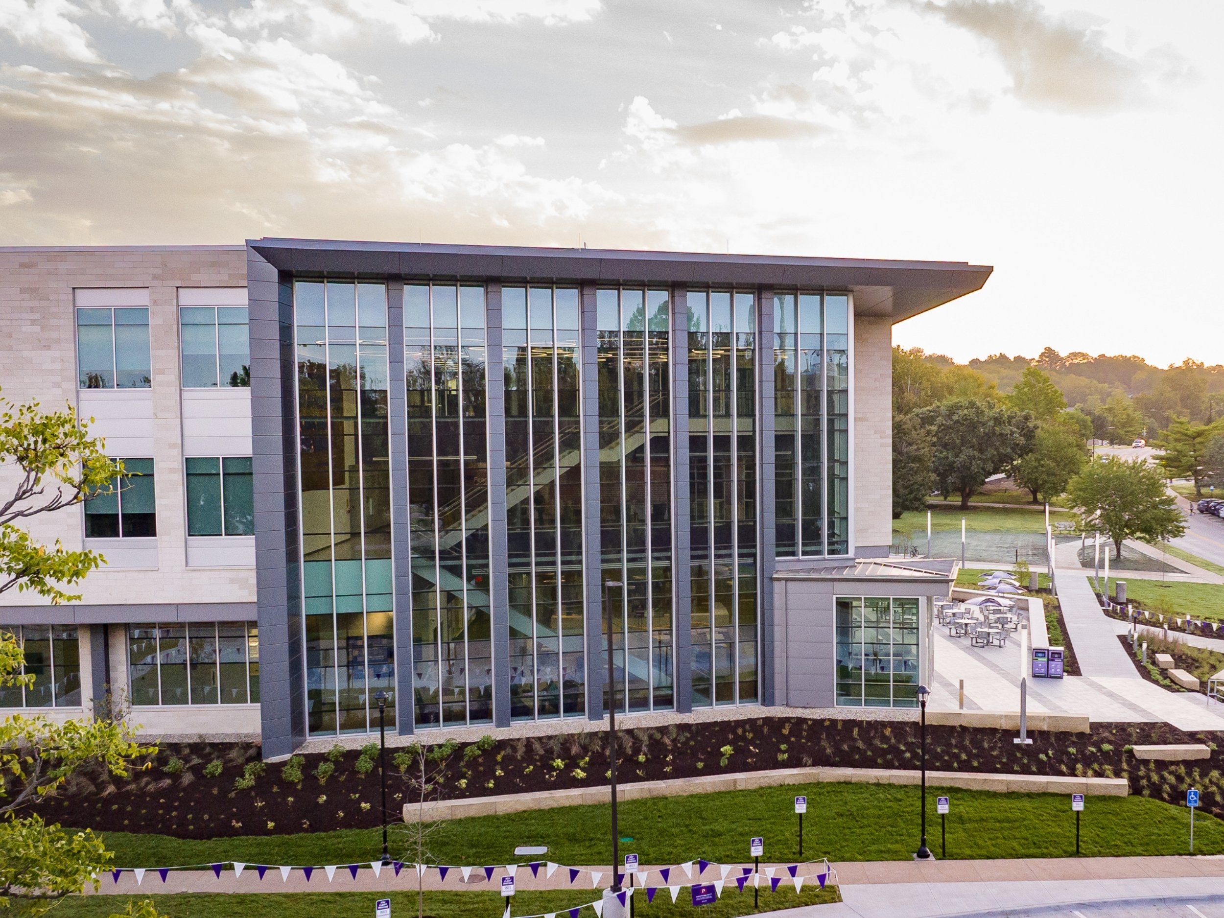 The photo of the exterior of the new Western Star Global Grain and Food Center, featuring tall, glass walls, limestone steps and a limestone sign with the building's name.