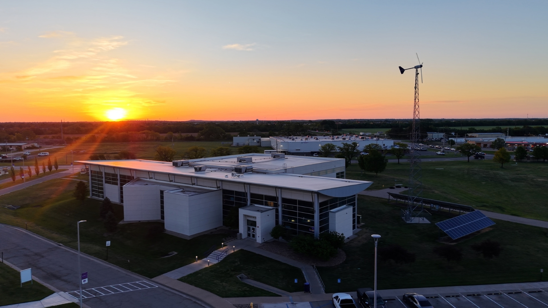 An aerial shot shows a college campus and its buildings during sunrise.