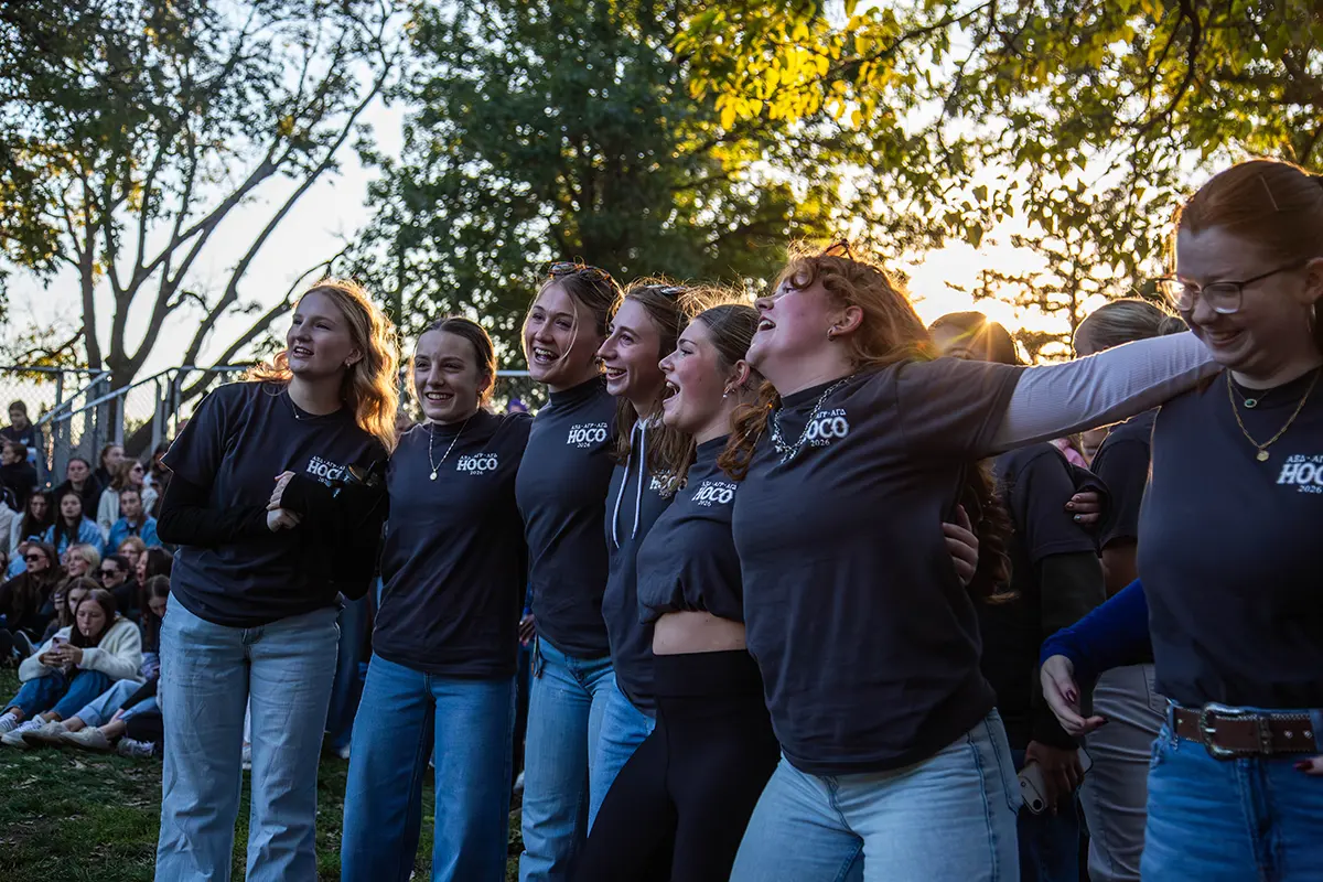 A group of sorority girls singing and dancing with each other.