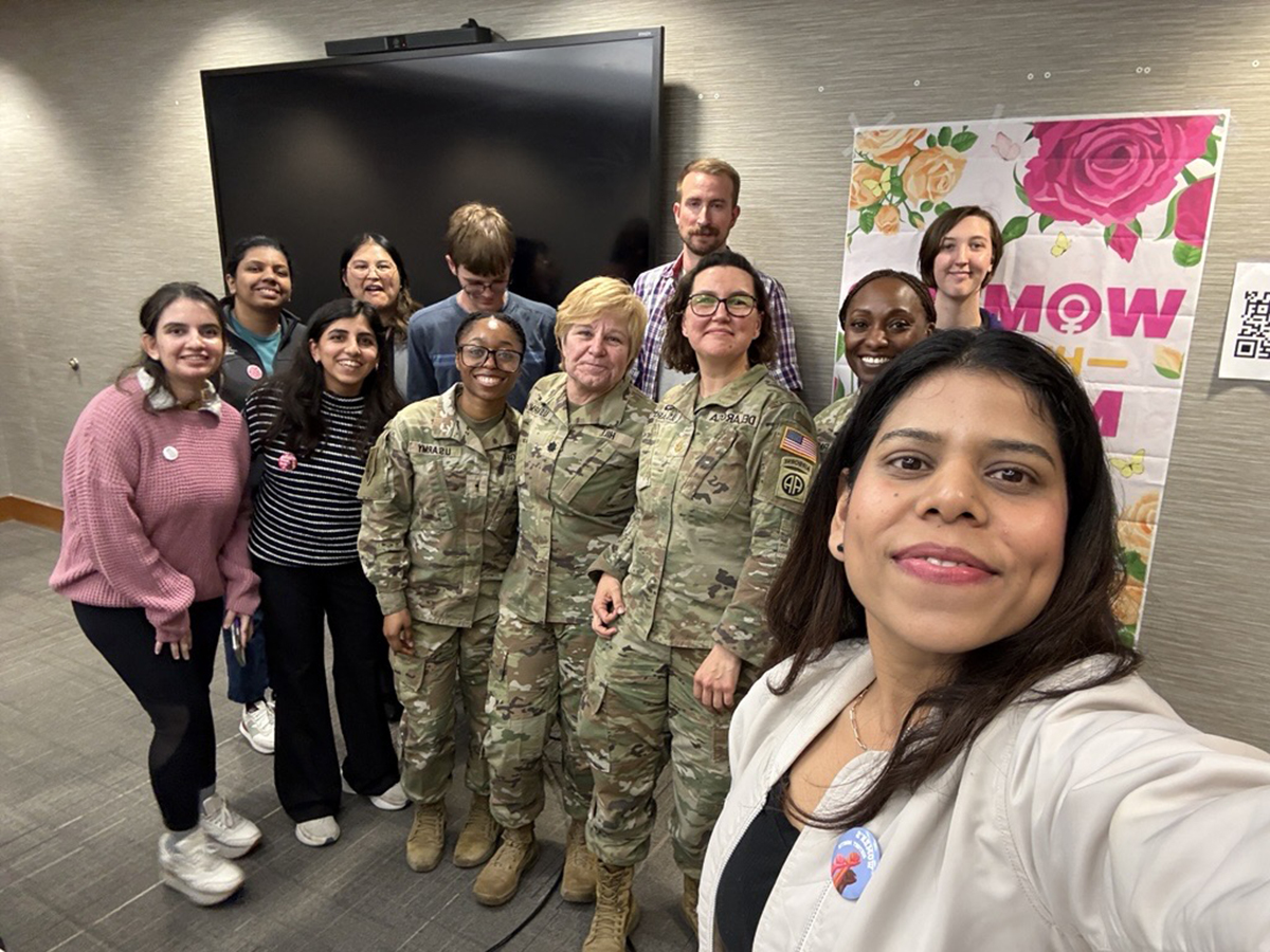 A woman takes a selfie with a group of women.