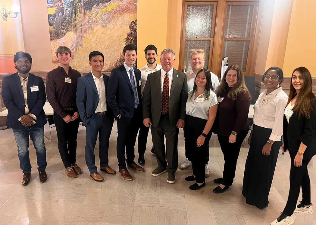 A group of student standing with a senator in the Kansas Capitol.