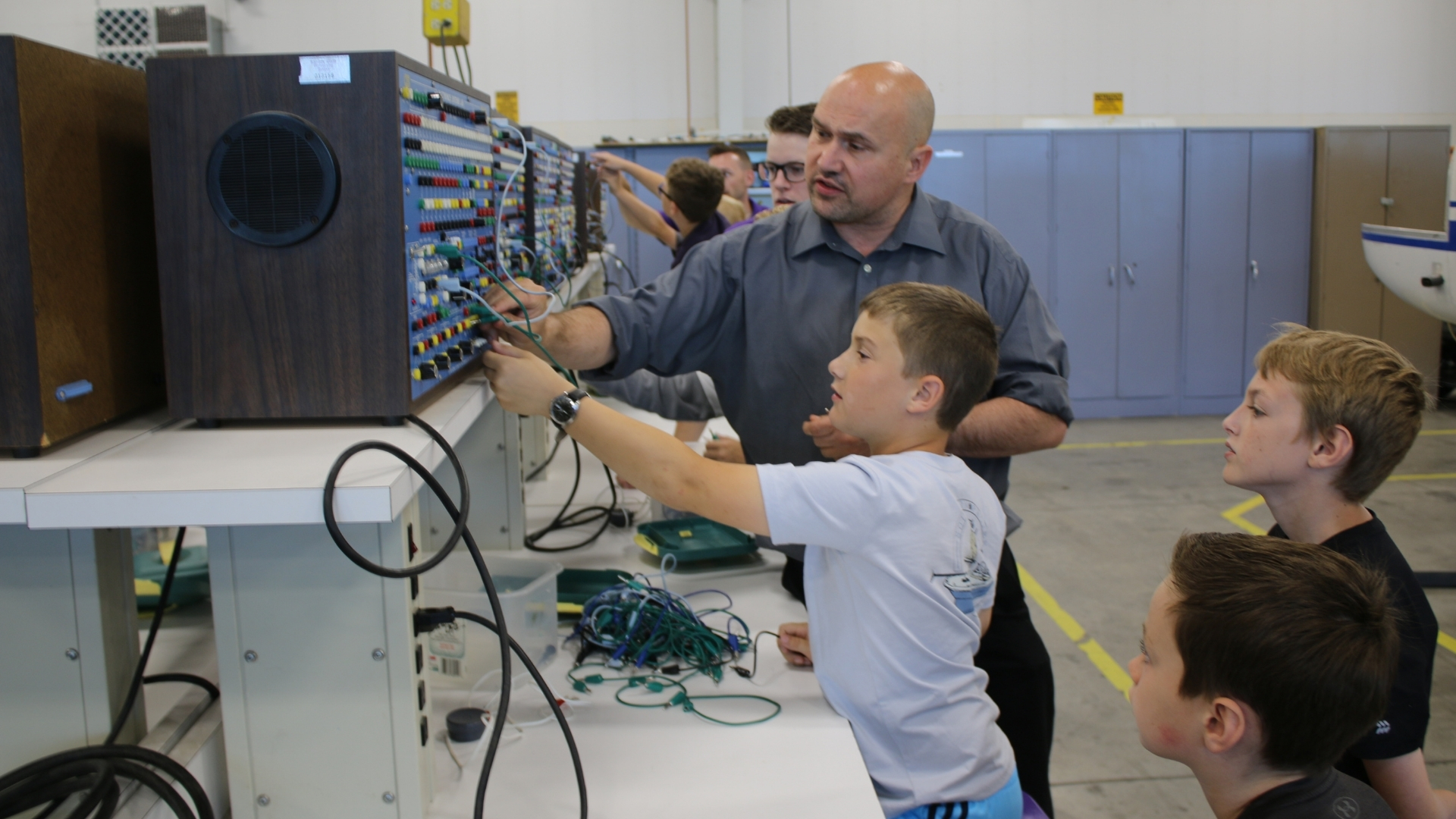 Kids interact with technology with the help of a faculty member