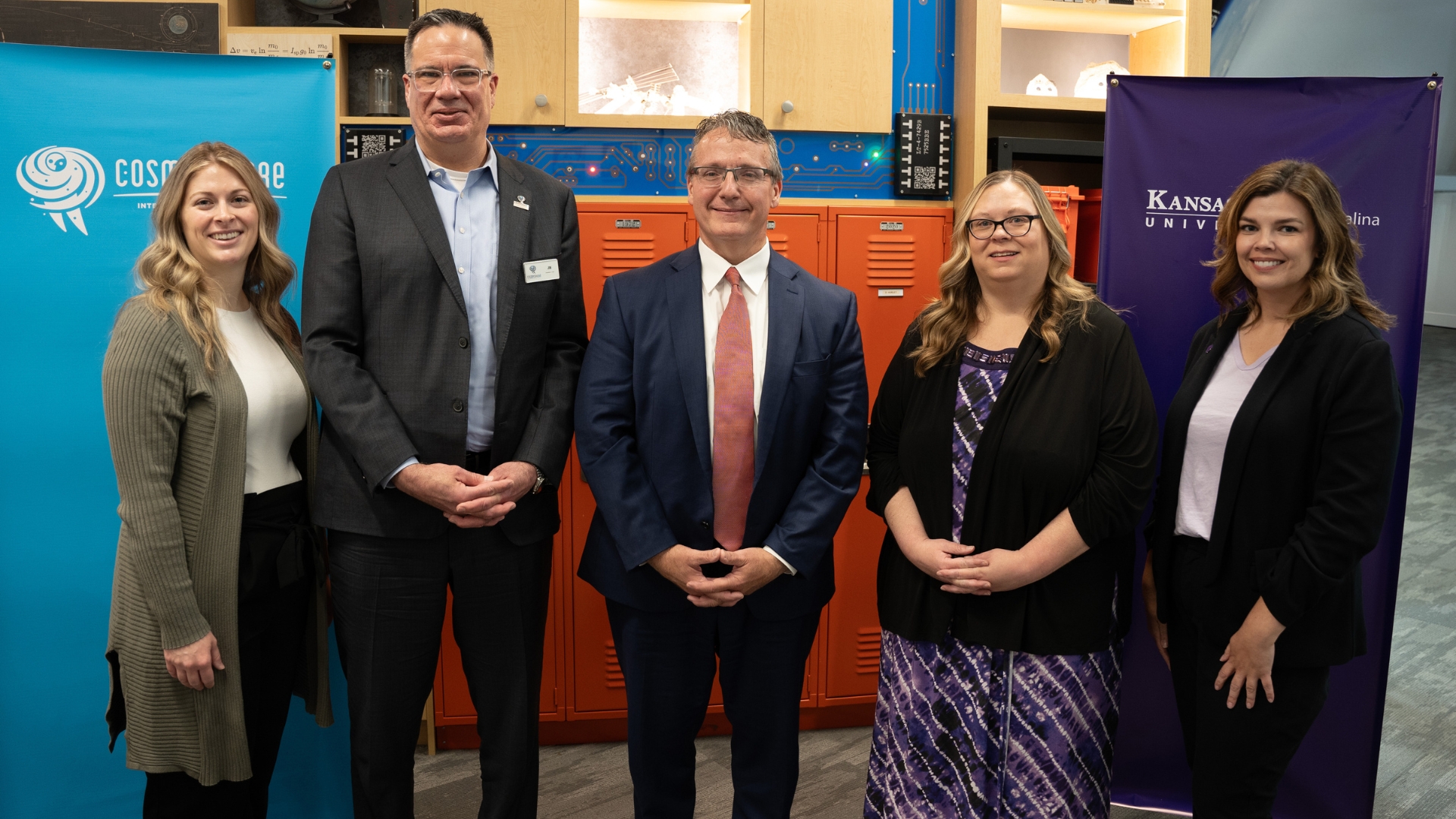 A group of people standing in front of banners