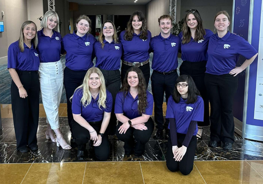A group of students, mostly women, lined up in purple polos.