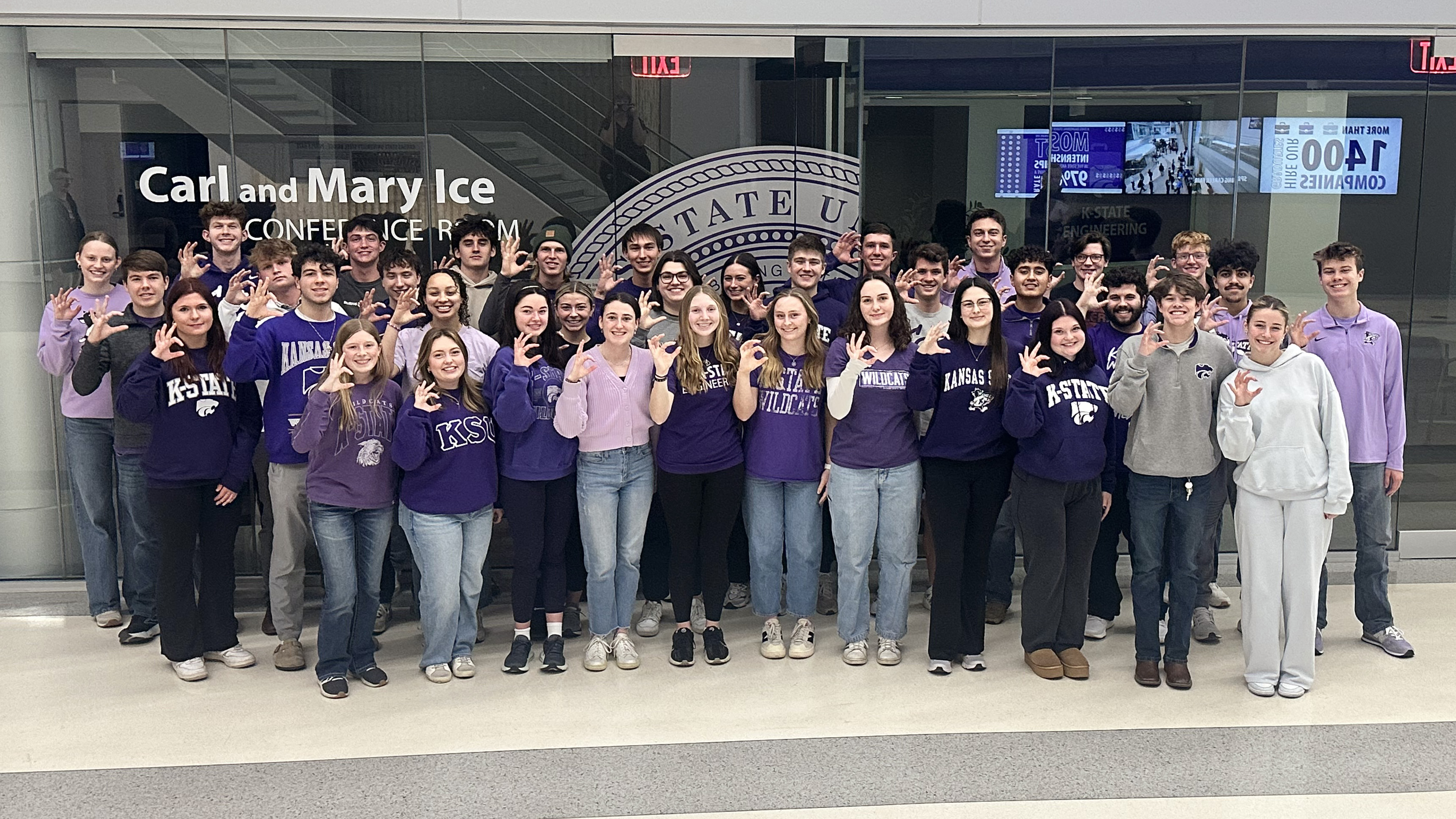 A group of students posing in front of a conference room