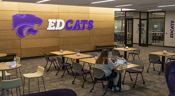 A purple Powercat logo and the word "Edcats" shine on a wooden wall in a study lobby.