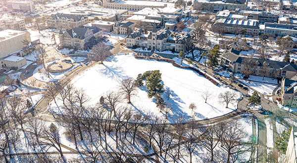 An aerial shot shows the Anderson Lawn covered in white snow in front of K-State's Anderson Hall.