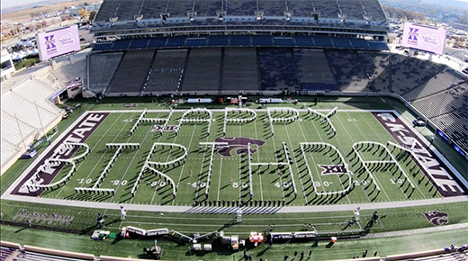 Band students spelling happy birthday on a field