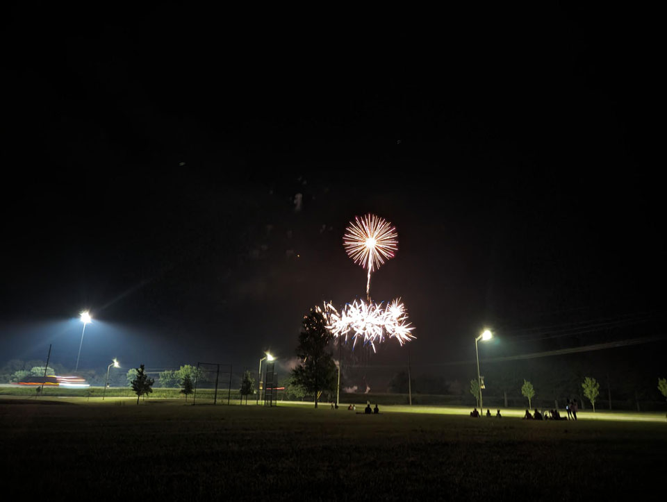 Fireworks explode at night. 