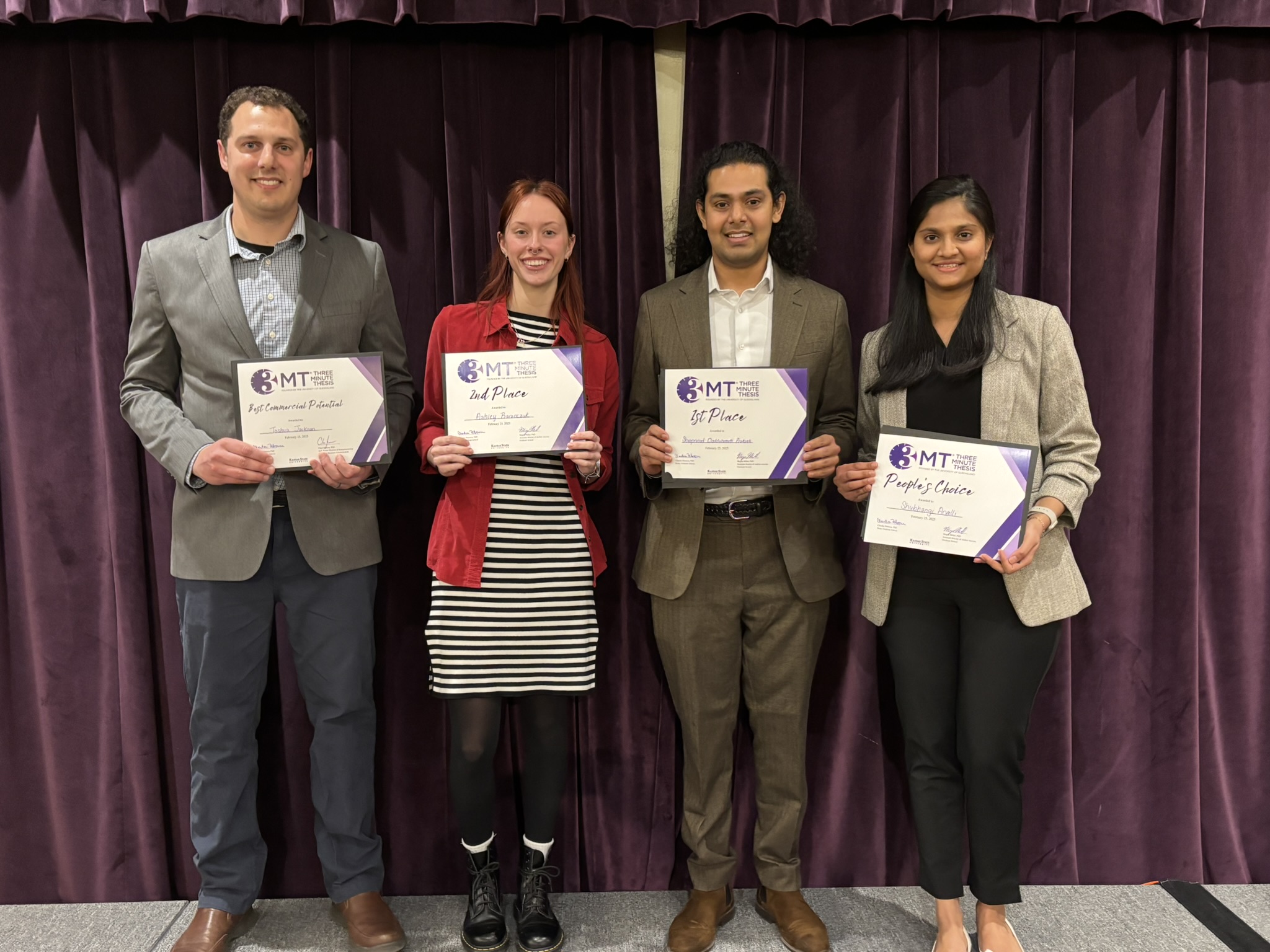 Four students standing with certificates