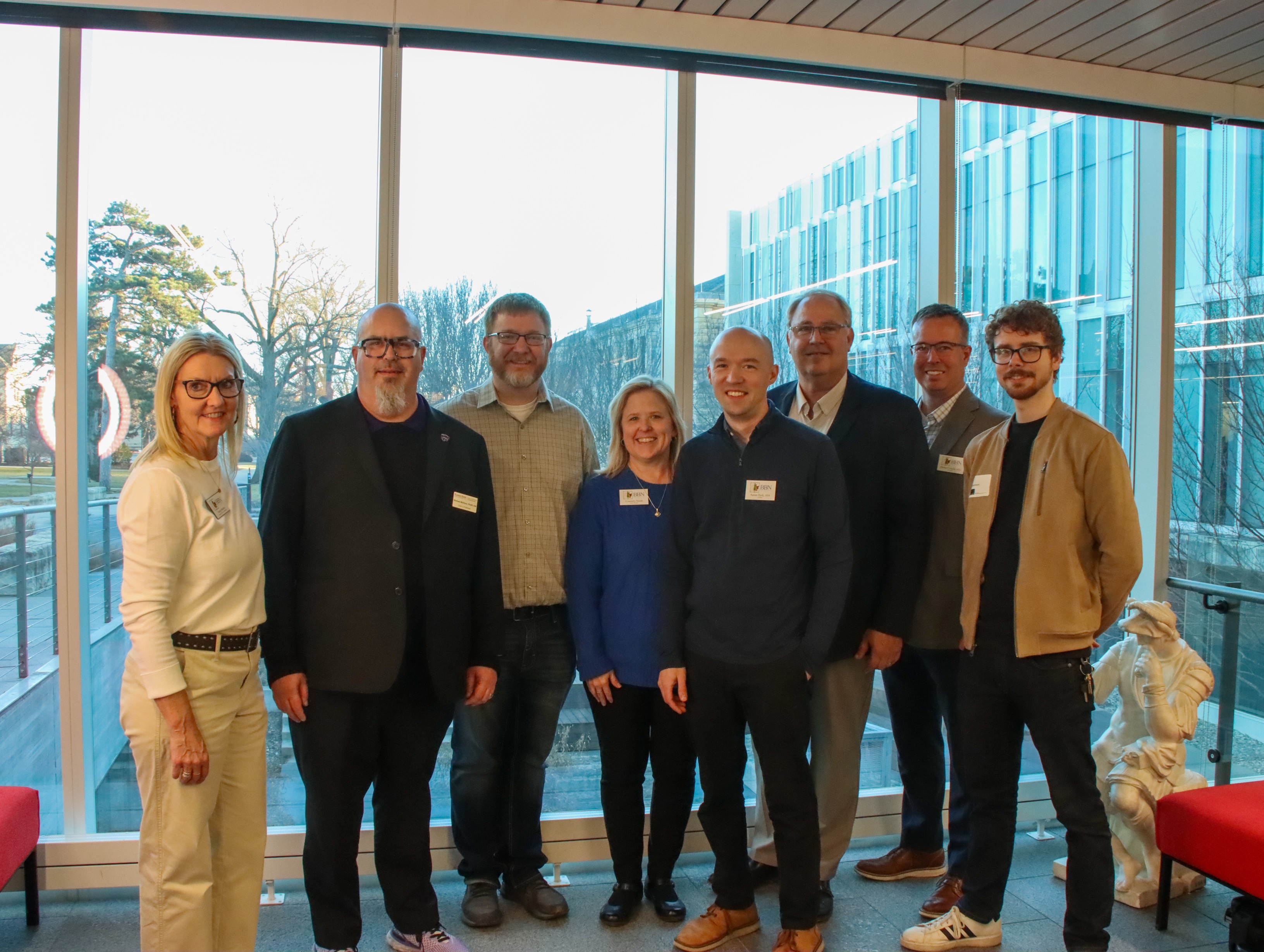 A group of architects standing in front of windows