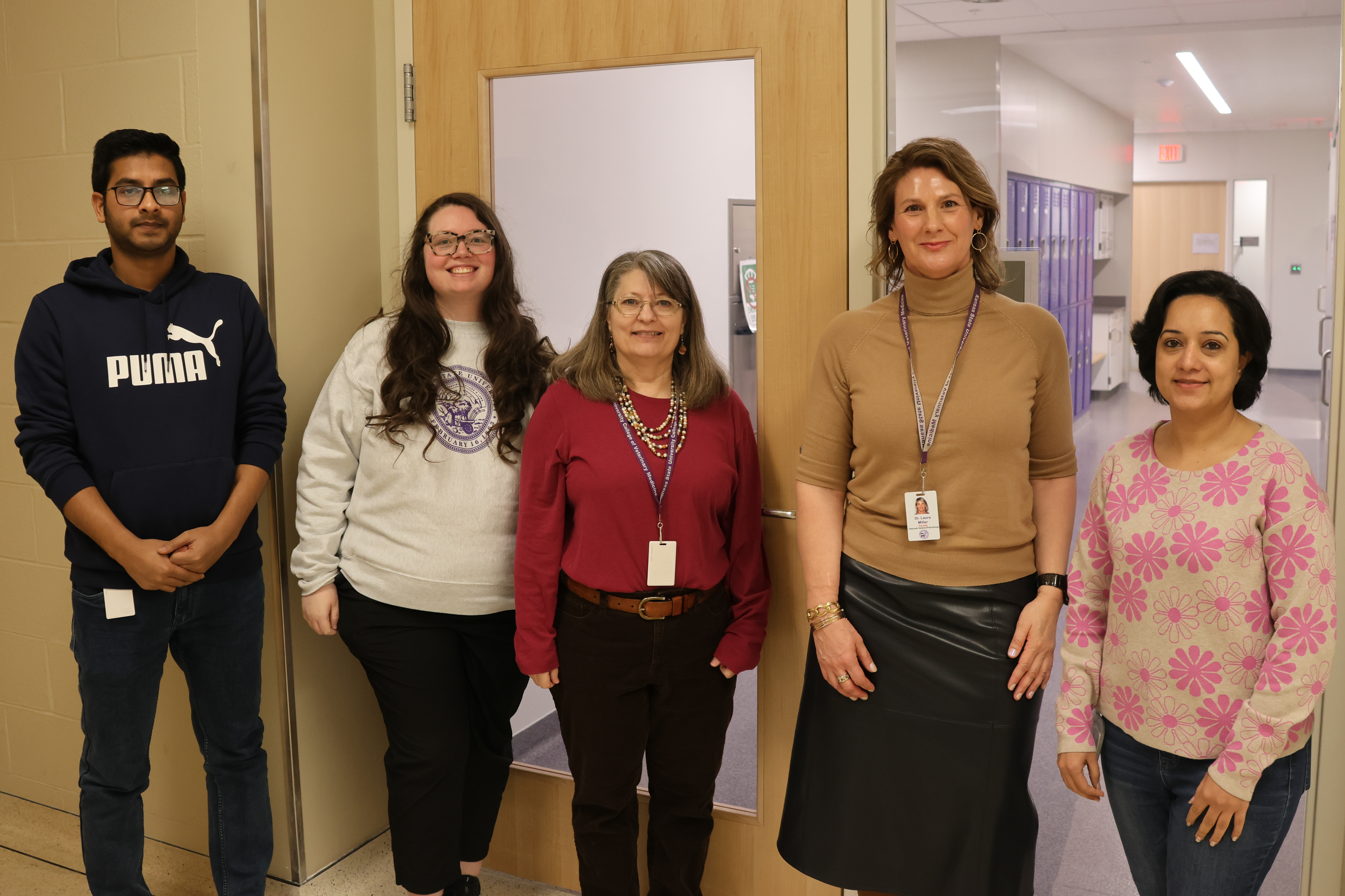 A group of researchers standing in a line smiling for a photo.