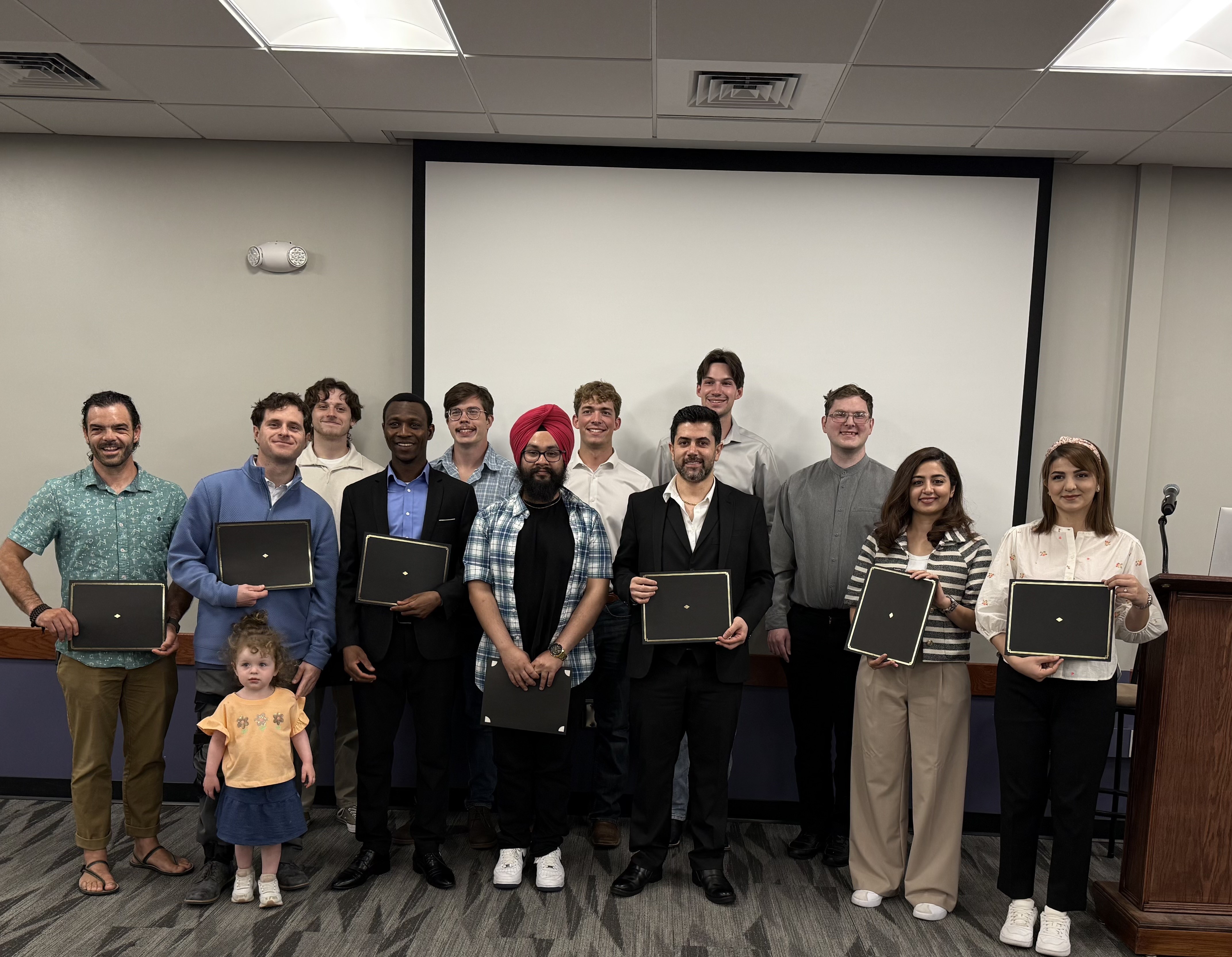 A group of a dozen college students pose for a group portrait at a scholarship reception.