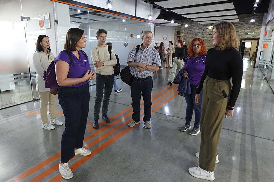 Several people meet and have a conversation in the hallway of a modern building housing an agriculture school in Ukraine.