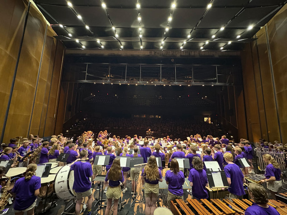 Band students in purple shirts perform a concert at McCain Auditorium.