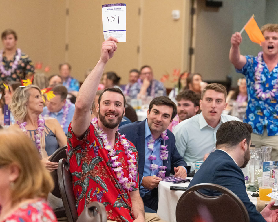 People sit at tables and bid on auction items.