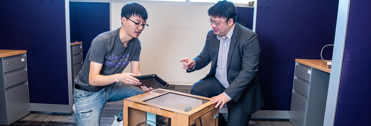 Xuebo Liu and Hongyu Wu ,Engineers look at a smart home energy management system they developed.
