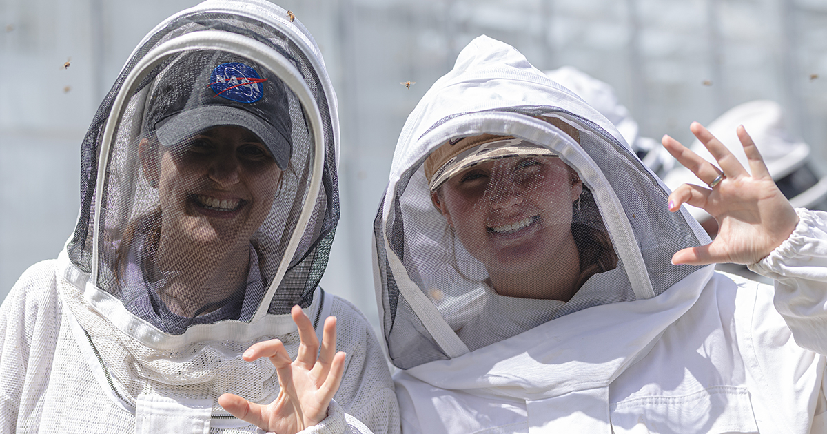 Female students hold up a powercat hand symbol.
