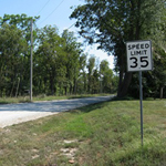 Speed limit sign on gravel road