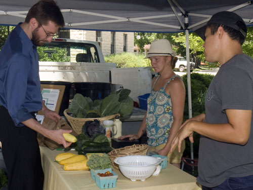 Ben Champion looks at vegetables for sale at the student farm kiosk.