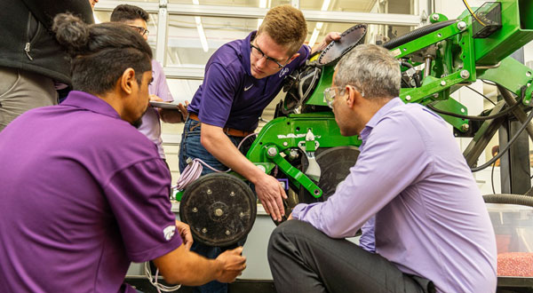 people looking at field equipment