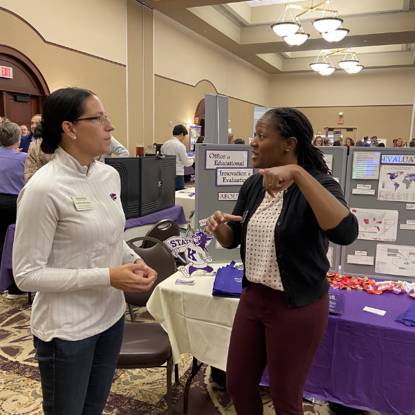 Two OEIE team members discussing a poster presentation