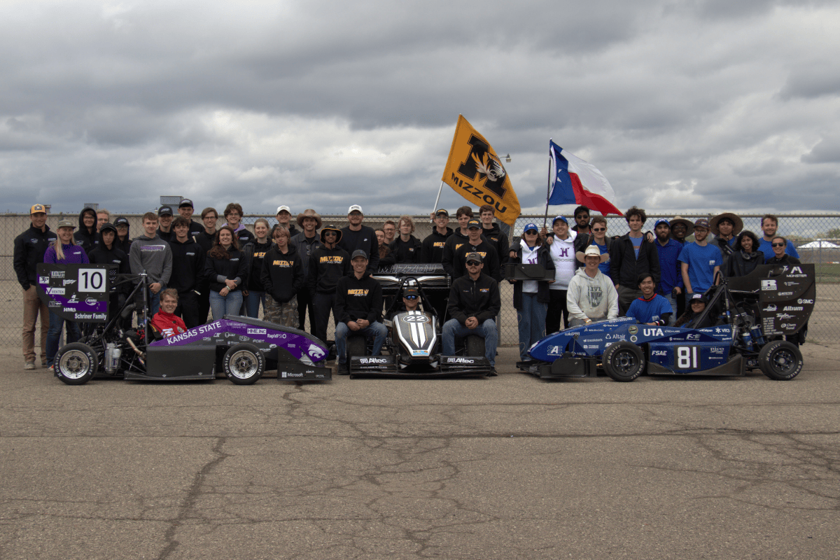 Sphinx and the team pose for a photo with mizzou and maua racing