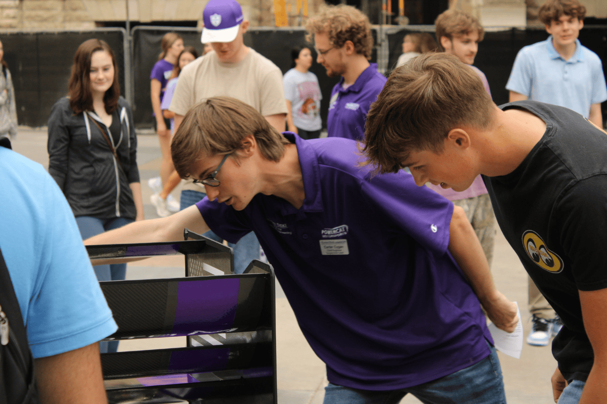 Carter leans over sphinx to explain things to a prospective student