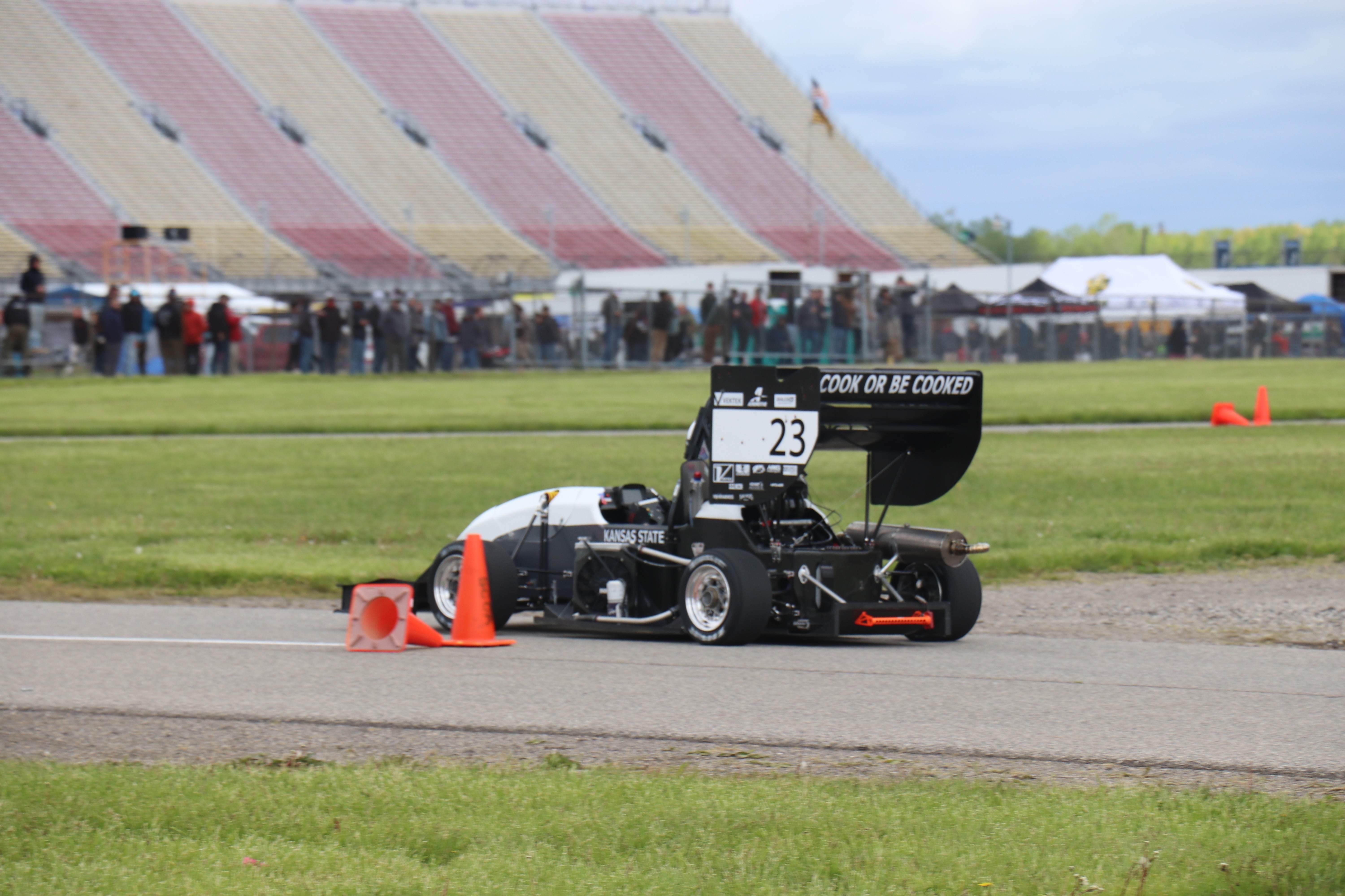 Our car with our phrase "cook or be cooked" on the back of the car visible while it is racing in the endurance event.